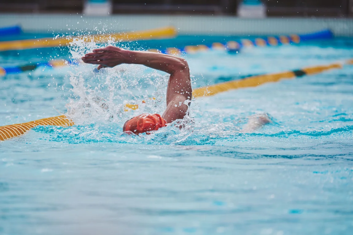 Coach giving one-to-one stroke feedback at the poolside