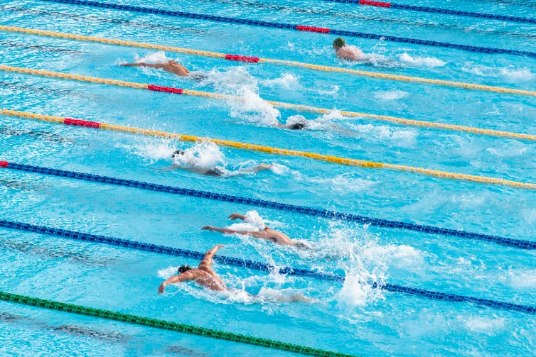Swimmers racing in an outdoor 50m pool